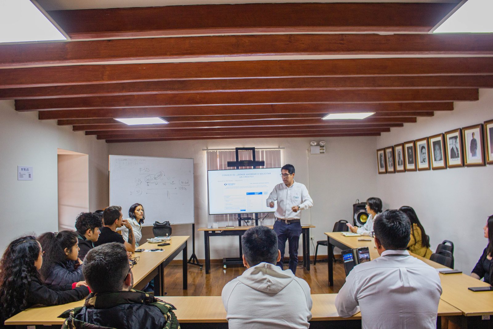 William Heras dictando una clase presencial a un grupo de participantes