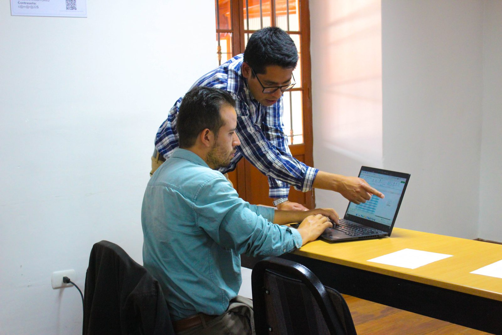 William Heras ayudando a un participante frente a su laptop